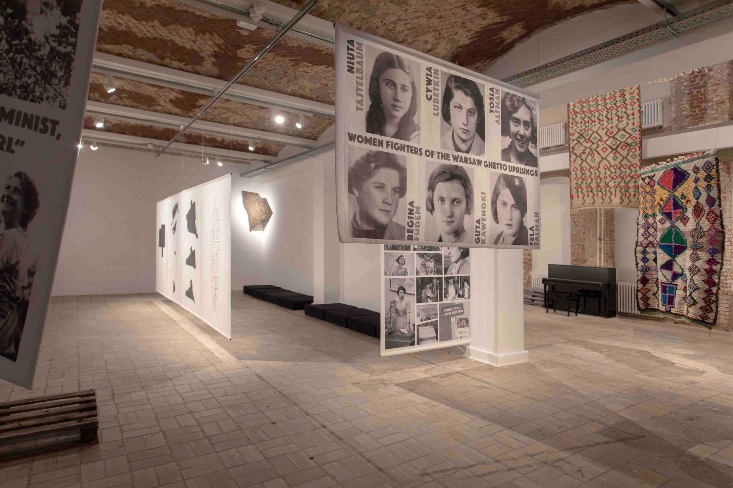 Myriam El Haïk, Zuzanna Hertzberg, installation view, 12th Berlin Biennale, KW Institute for Contemporary Art, 11.6.–18.9.2022

Photo: Silke Briel

 

From left to right:

 

Zuzanna Hertzberg, Mechitza. Individual and Organized Resistance of Women During the Holocaust, 2019-22

5 textile banners with photo prints; performative activation

 

Myriam El Haïk, Please Patterns, 2022

Installation and performance for drawings, rugs, and piano